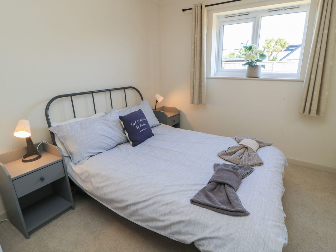 A bedroom with a bed and nightstand at Bayview Cottage Southbourne