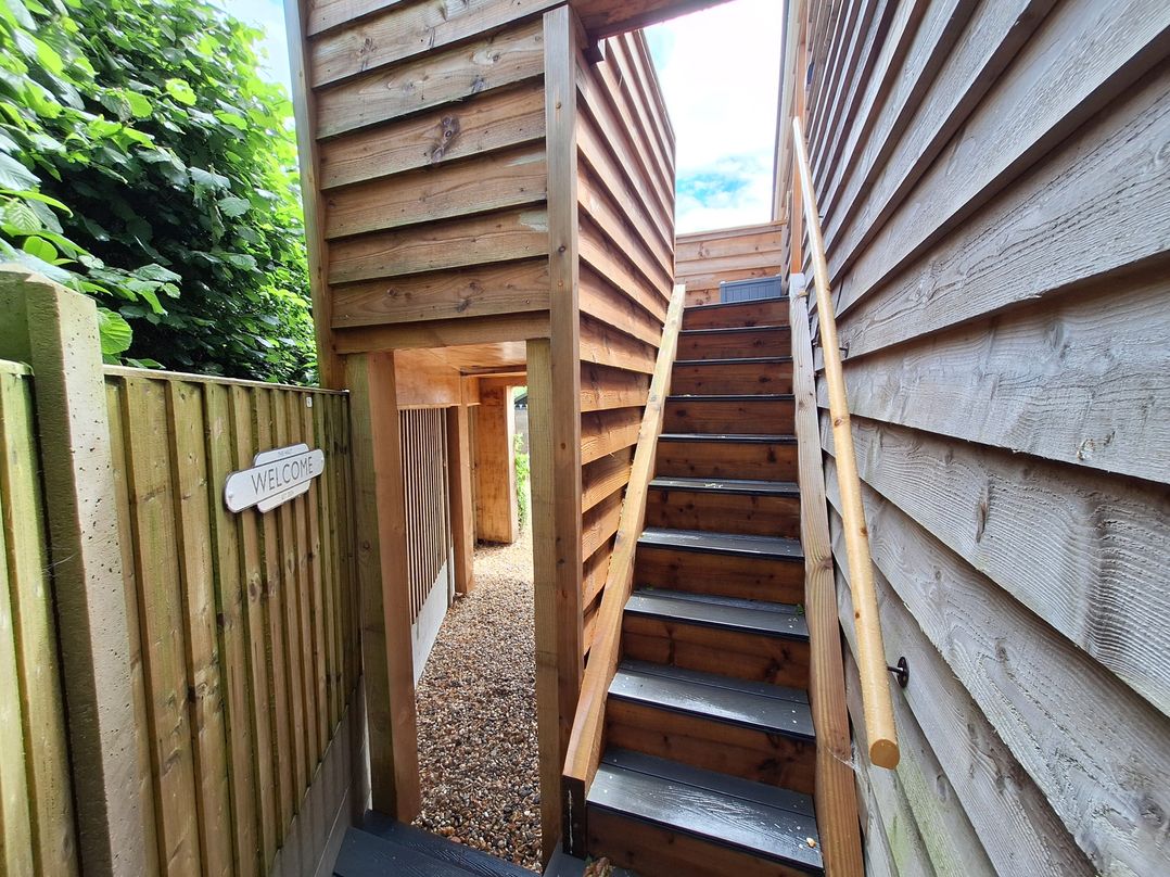 An outdoor area with stairs and a welcome sign at The Halt in Maiden Newton