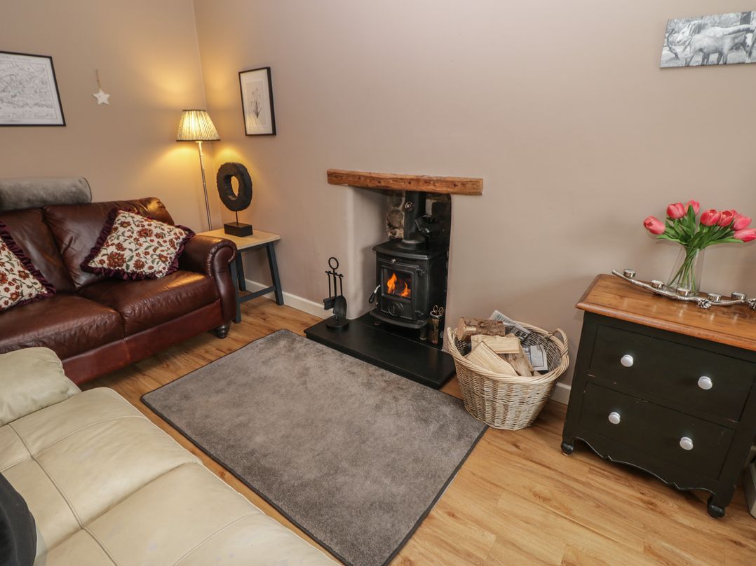 A living room with a fireplace and a sofa at Rose Cottage Hartington