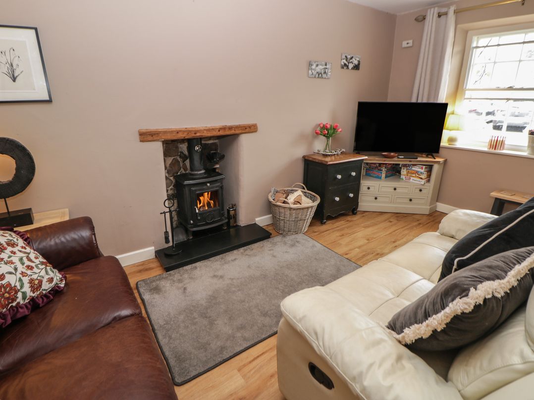 A living room with a fireplace and sofa at Rose Cottage in Hartington