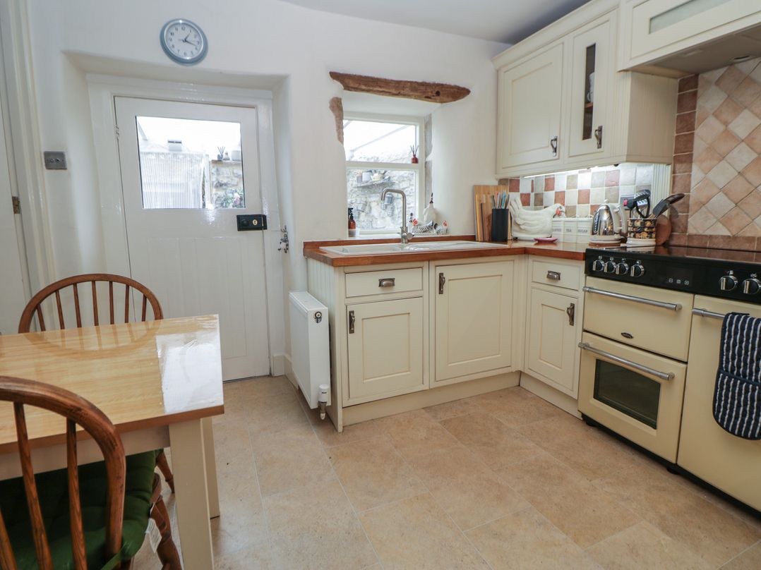 A kitchen with a table and chair at Rose Cottage in Hartington