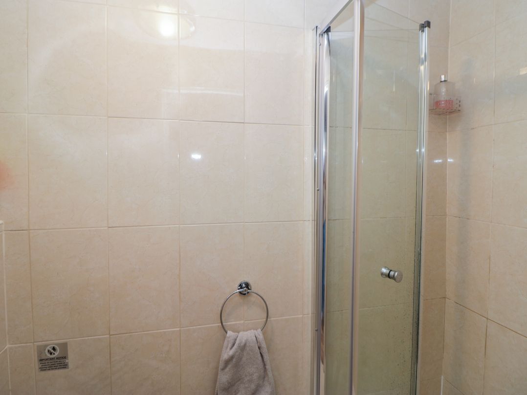 A bathroom with a shower and towel rack at Rose Cottage in Hartington