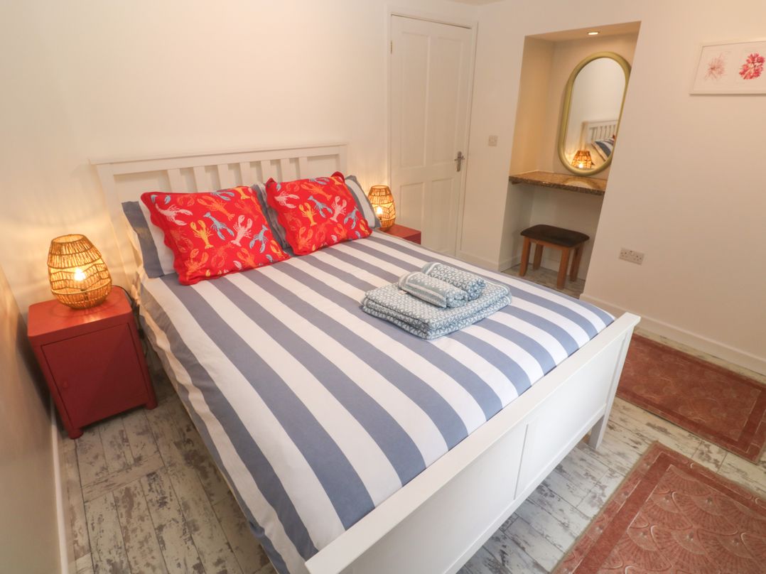 A bedroom with a bed and nightstand at The Packing House in Rosudgeon