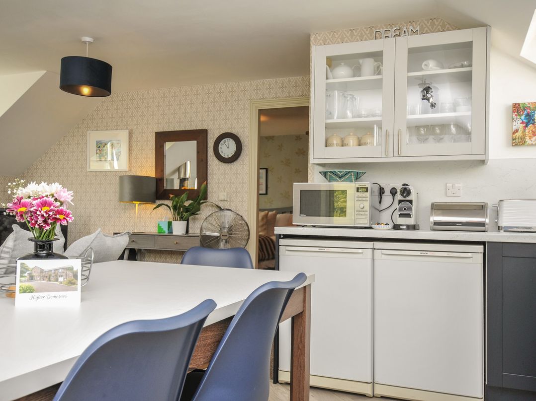 A kitchen with a dining table and appliances at The Hayloft in Lostwithiel