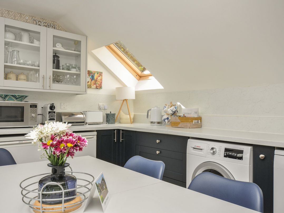 A kitchen with appliances and a table at The Hayloft in Lostwithiel
