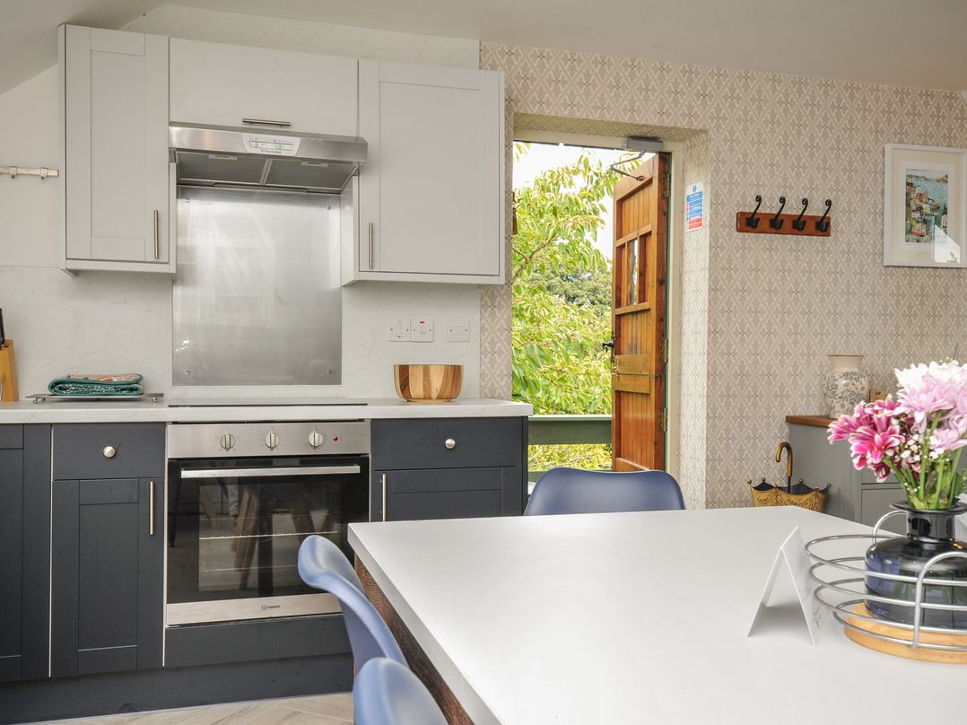 A kitchen with cabinets and appliances at The Hayloft in Lostwithiel