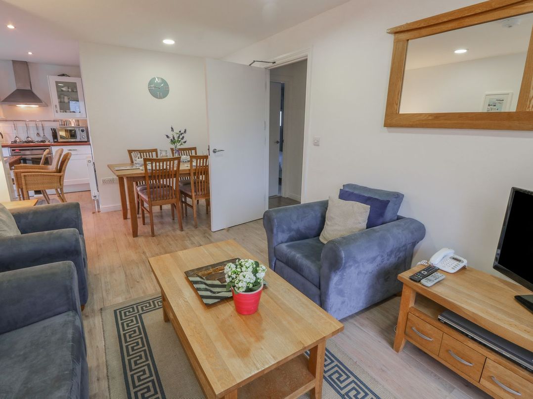 A living room with armchairs a coffee table and a dining table in the background at Pierpont D1 Norton near Yarmouth