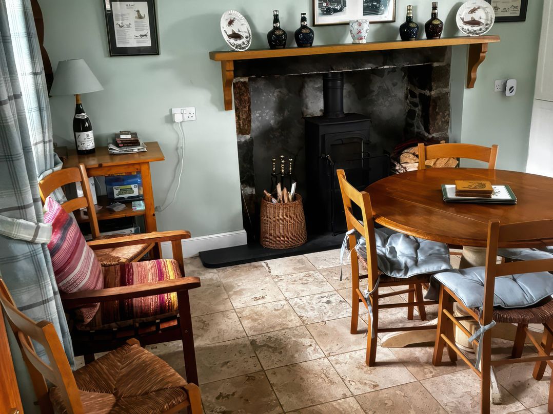 A dining room with a table and chairs at Strathnoon Clune near Carrbridge