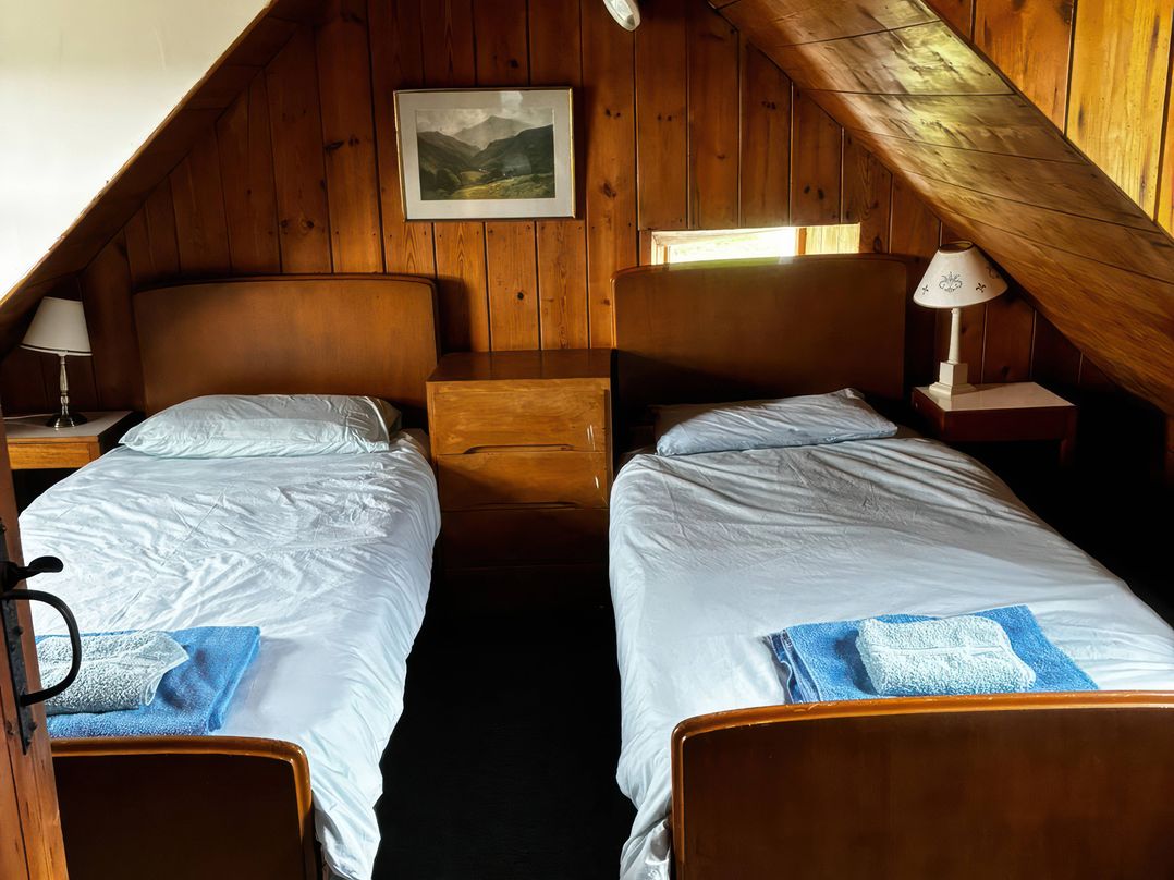 A bedroom with two beds and a window at Strathnoon in Clune near Carrbridge