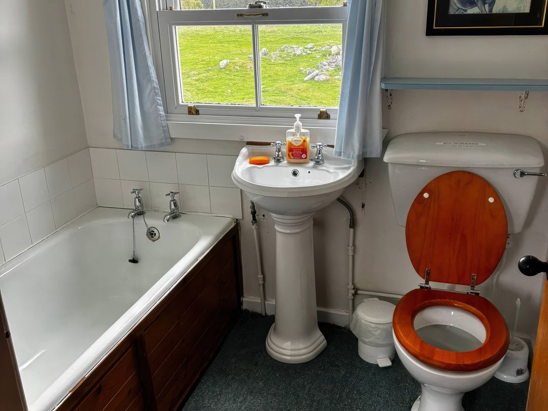 A bathroom with a bathtub, sink, and toilet at Strathnoon in Clune near Carrbridge