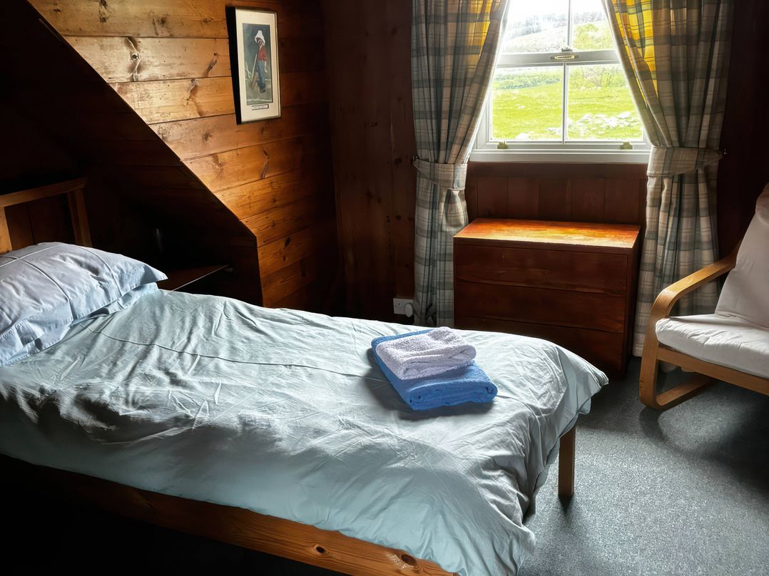 A bedroom with a bed and towels on it at Strathnoon in Clune near Carrbridge