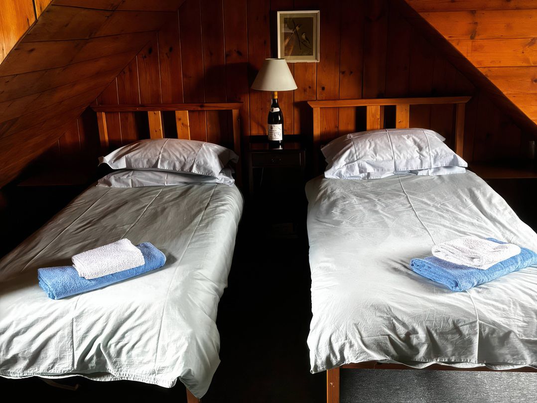 A bedroom with two single beds and a bedside table at Strathnoon in Clune near Carrbridge