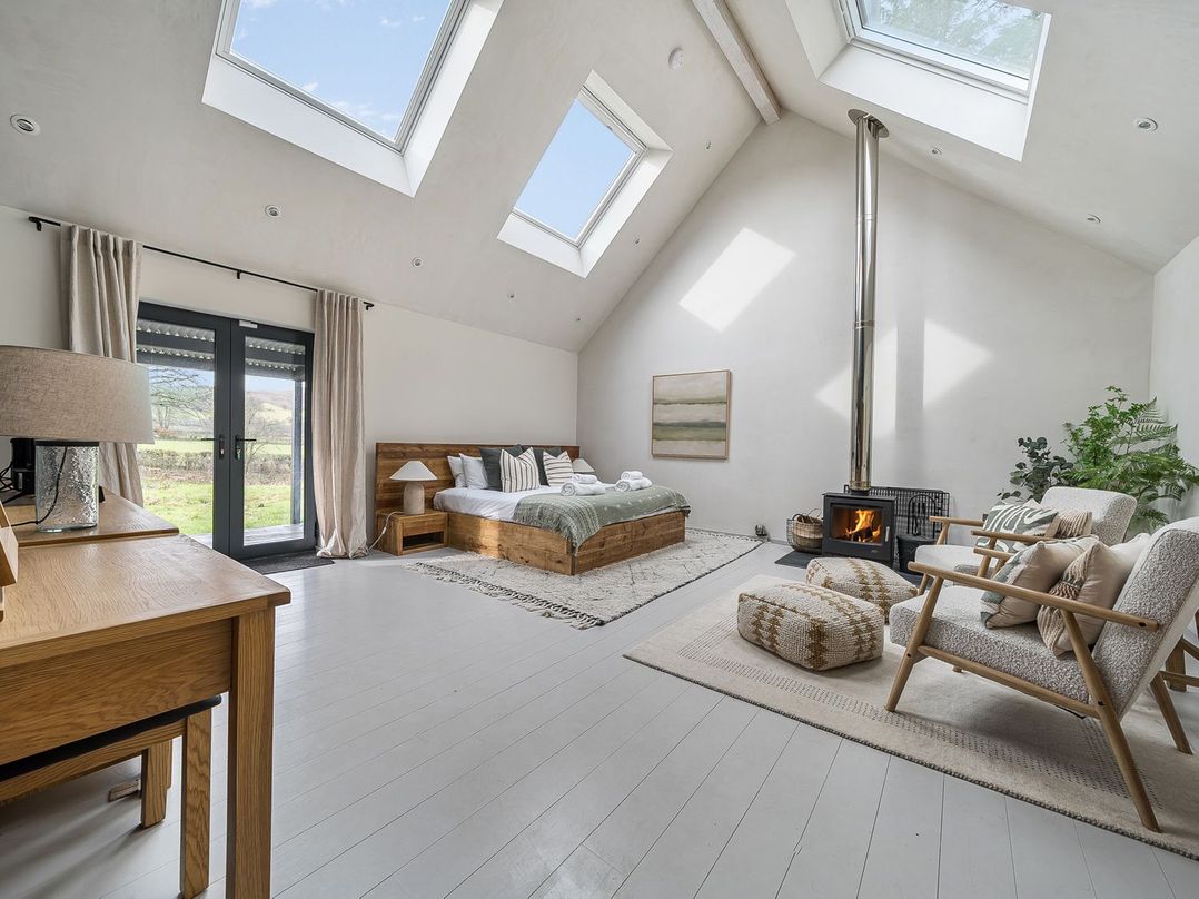 A bedroom with a bed and fireplace at Grove Cottage in Gladestry