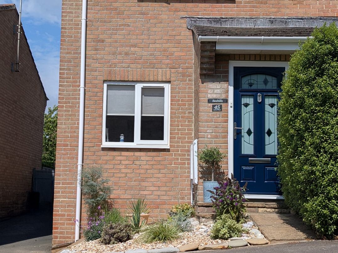 An outdoor view of a house exterior with a blue door at Seahills in Lyme Regis