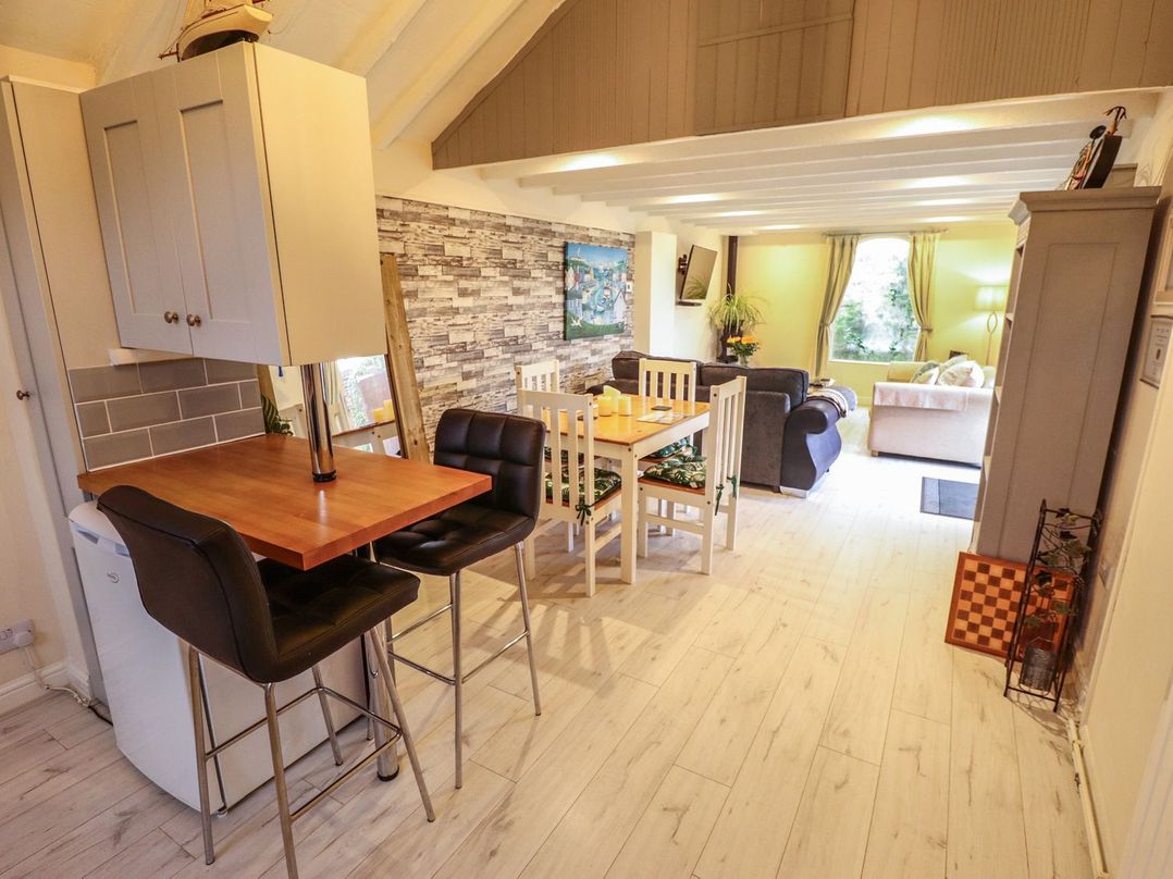 An open living and dining area with a breakfast bar and two stools at Sunnyside in Goxhill near Barrow-Upon-Humber