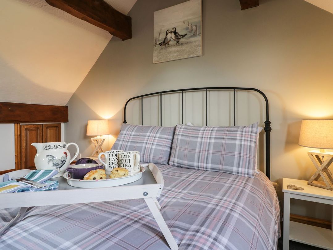 A bedroom with a bed and a tray with tea and cookies at Cyffdy Cottage - Aran Bala