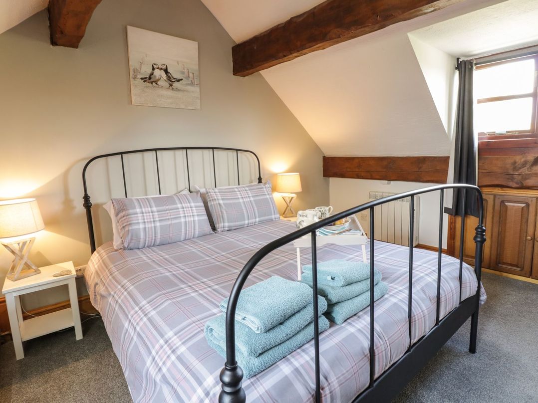 A bedroom with a bed, towels, and a window at Cyffdy Cottage - Aran Bala