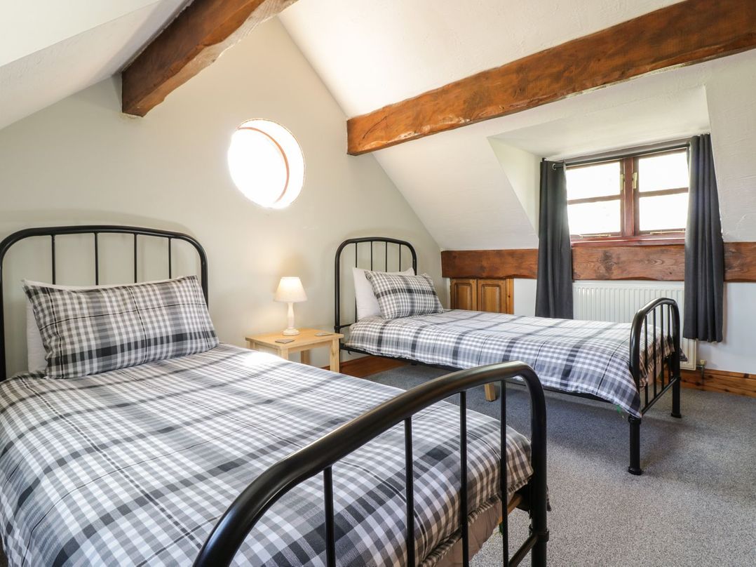 A bedroom with two beds and a lamp at Cyffdy Cottage - Aran in Bala