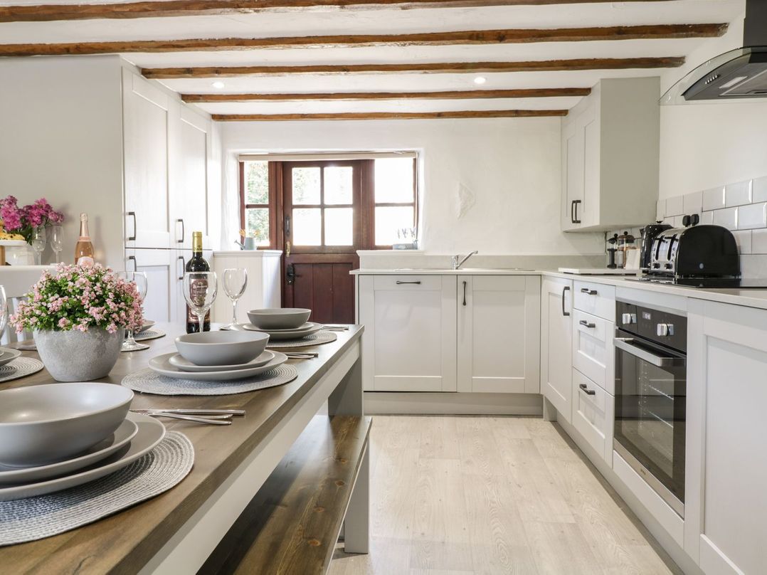A kitchen with dining table set for dinner at Cyffdy Cottage - Arenig Bala