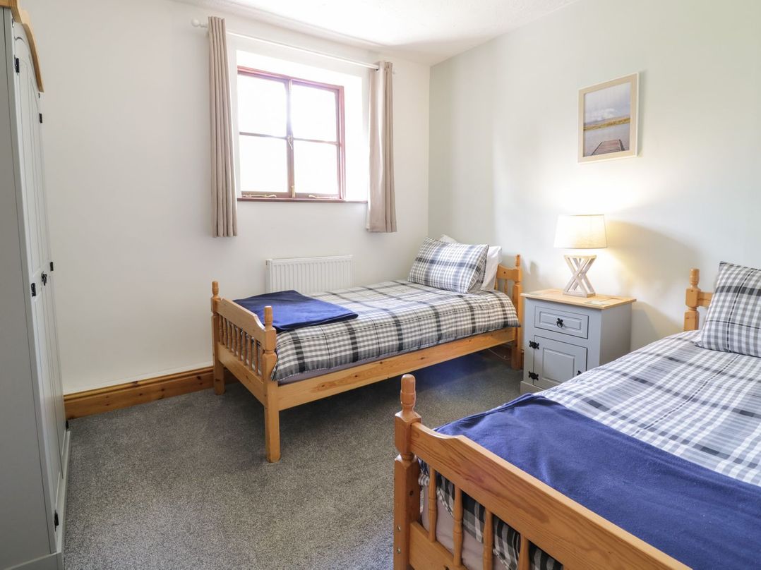 A bedroom with two beds and a bedside table at Cyffdy Cottage - Arenig in Bala