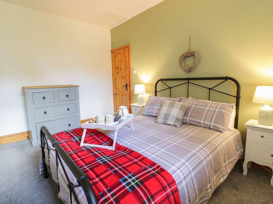 A bedroom with a bed and a dresser at Cyffdy Cottage - Arenig in Bala