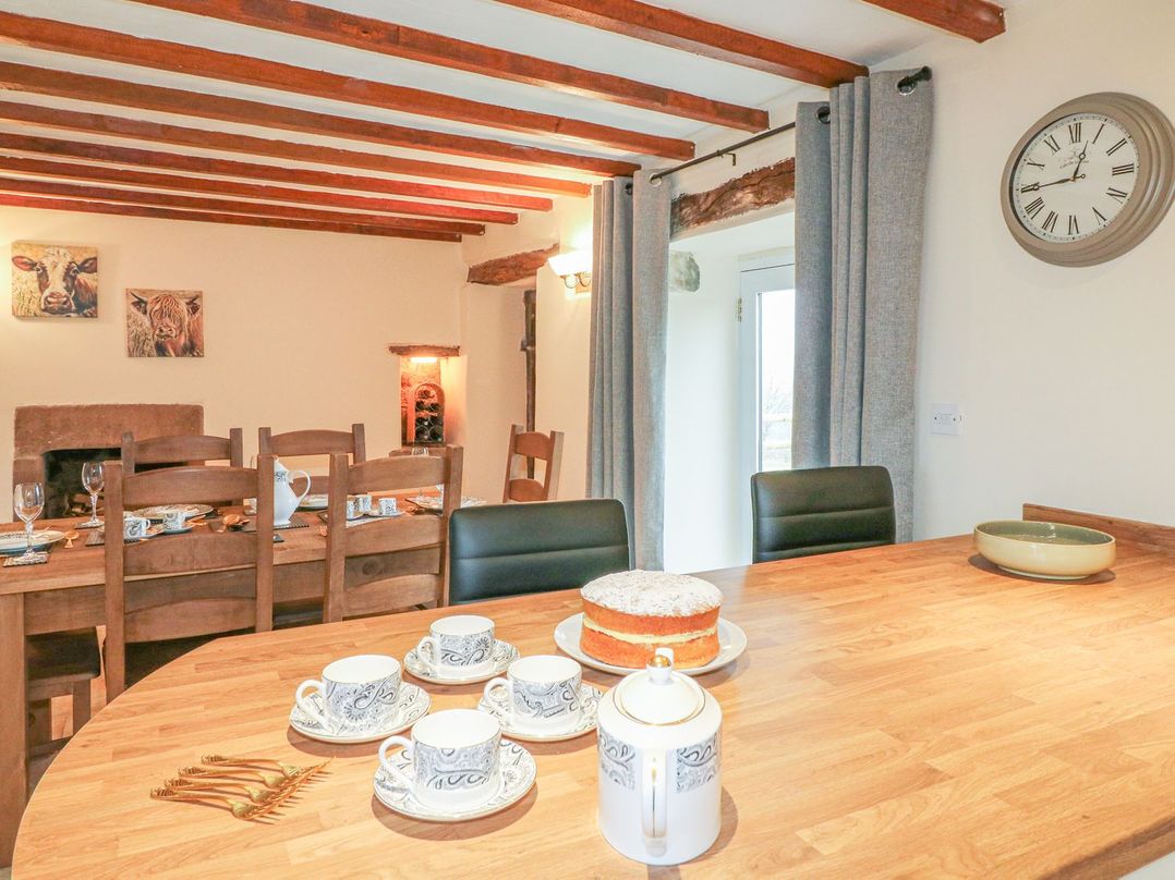 A dining room with wooden table set with cups plates and cake at Lane Head Cottage in Alderwasley near Wirksworth