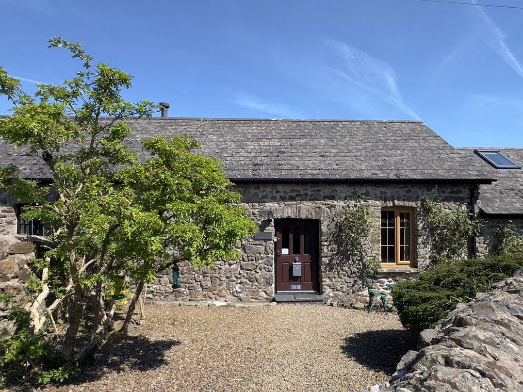 An outdoor view of a stone cottage with a door and windows at 8 Rogeston Cottages Haverfordwest