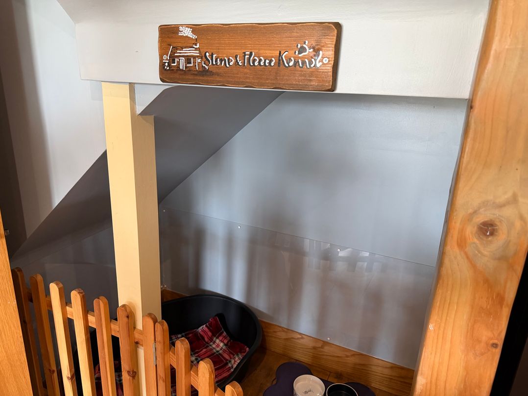 A pet nook with a dog bed and food bowls at Stone & Fleece Cottage in Holmfirth