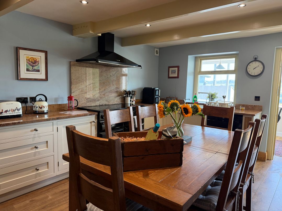 A kitchen with a table and chairs at Stone & Fleece Cottage in Holmfirth