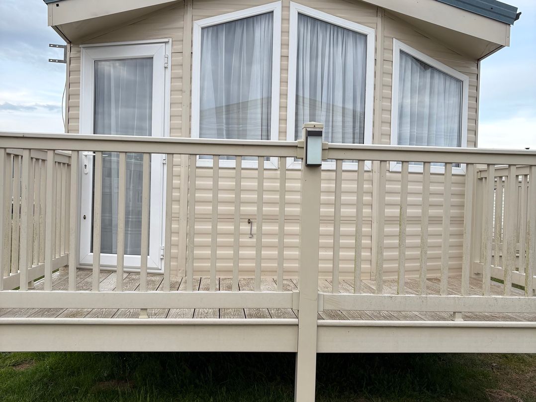 An outdoor deck area with a door and windows at Caravan 607 Clacton-On-Sea