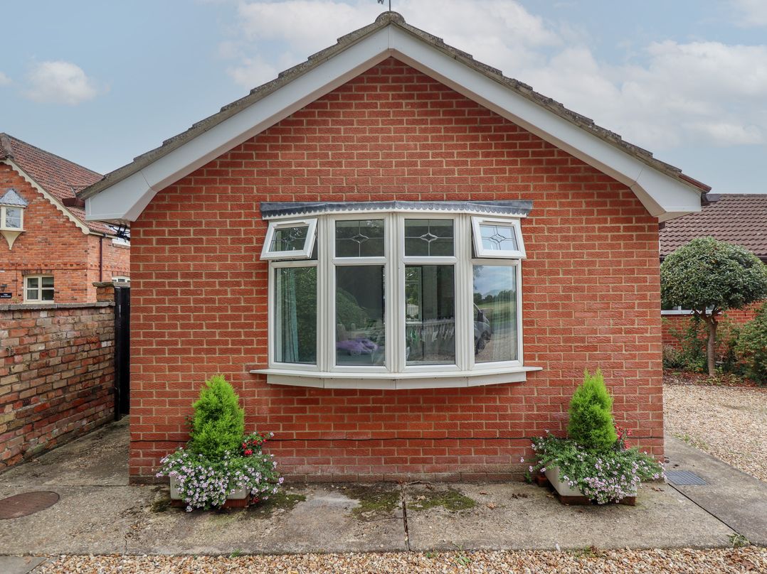 A brick exterior with a window and planters at Southfields Annex Little Carlton near Louth