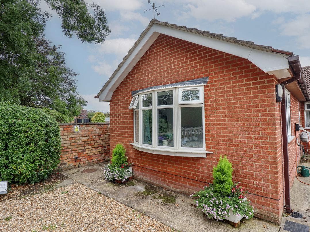 A brick exterior of a house with a window and flower pots at Southfields Annex in Little Carlton near Louth