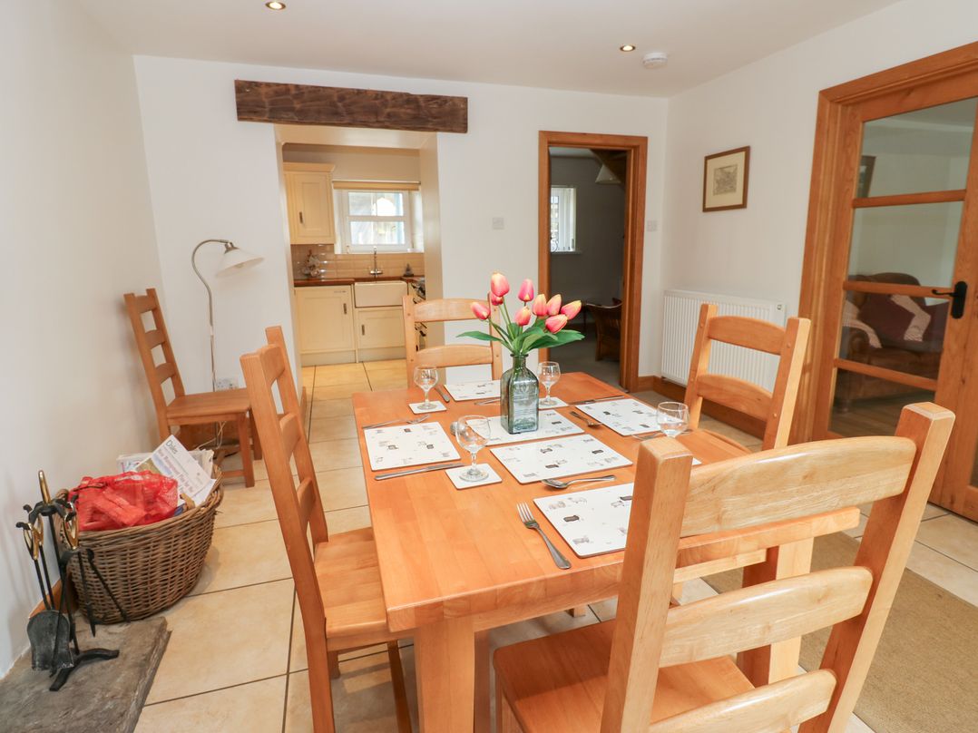 A dining room with a wooden table and chairs at Bridge House