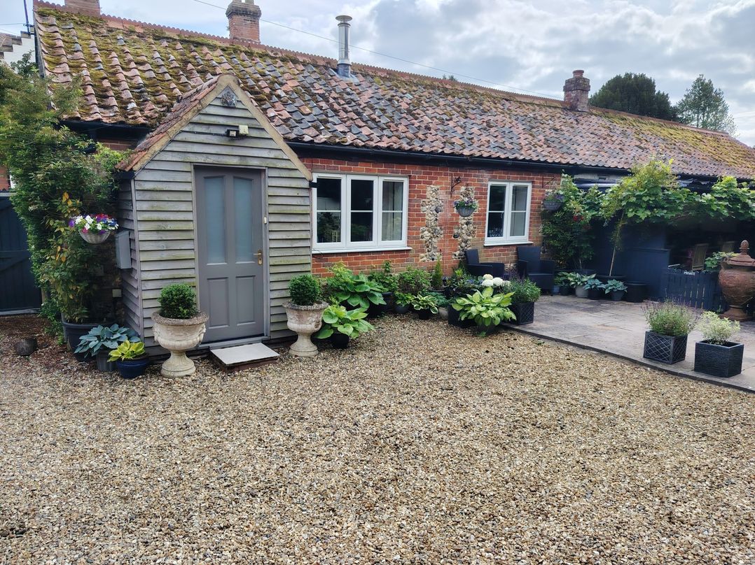 A garden with plants and a wooden garden shed at Cosy Cottage in North Elmham