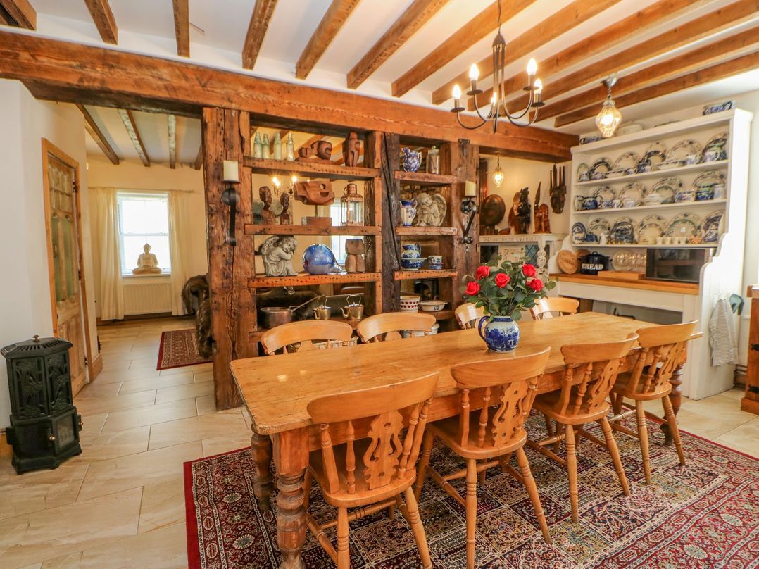 A dining room with a wooden table and chairs and decorated shelves at Shaftoe Mews in Haydon Bridge