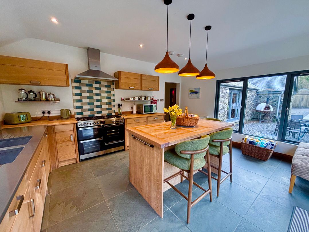 A kitchen with an island and stools at Bracken Ground in Coniston