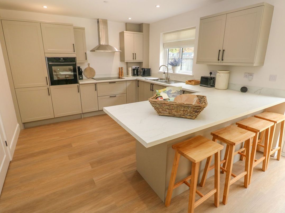 A kitchen with a countertop and stools at Hafan Y Gof in Newcastle Emlyn