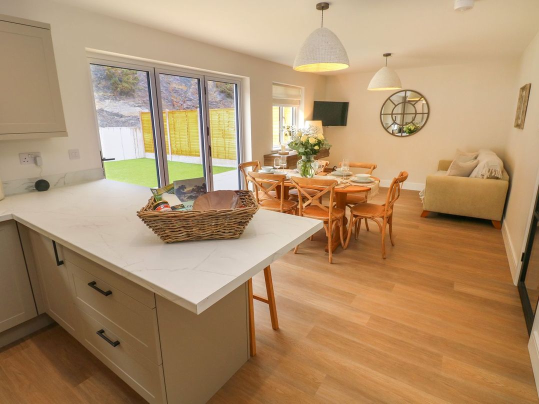 A kitchen and dining area with a table and chairs at Hafan Y Gof Newcastle Emlyn