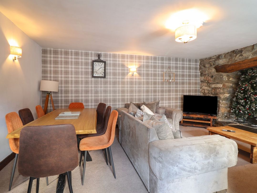 A living room with a dining table and sofa at Cader Cottage in Dolgellau