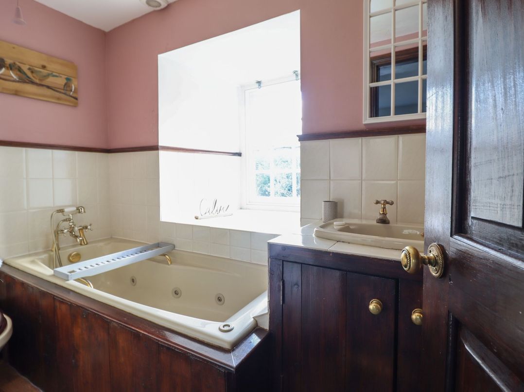 A bathroom with a bathtub and sink at Cader Cottage in Dolgellau