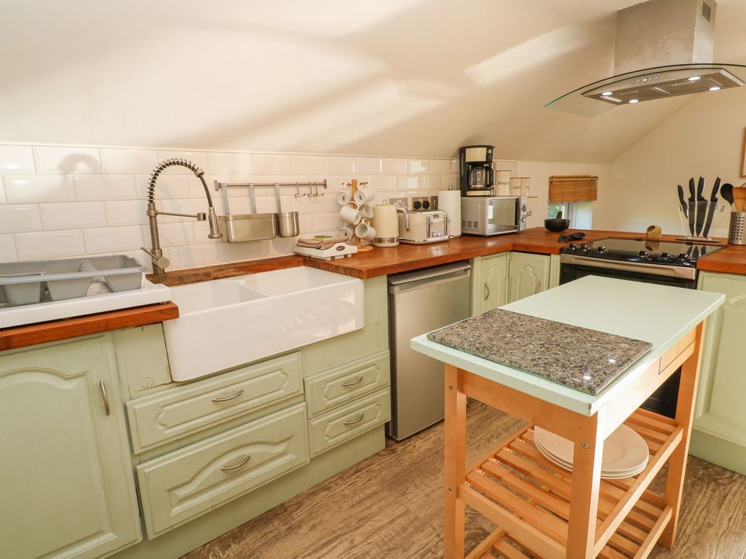 A kitchen with countertop, sink, and appliances at Five Elements Barn in Truro
