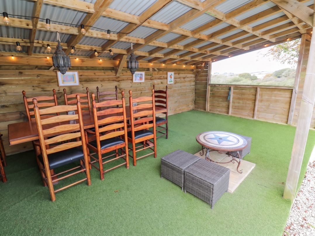 An outdoor dining area with a table and chairs at Five Elements Barn in St Agnes