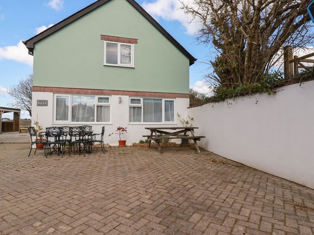 A house with a table and chairs in the outdoor area at Five Elements Barn, St Agnes