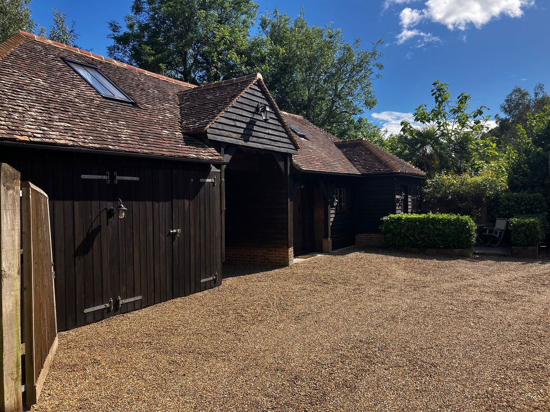 An outdoor area with a building and trees at The Hayloft - Beautiful Barn Stay, Charing