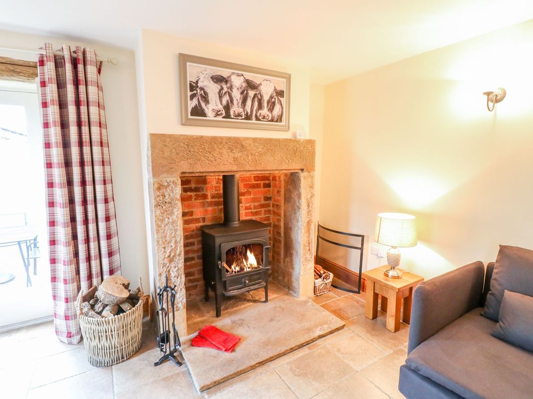 A living room with a wood stove and a sofa at The Barn in Wirksworth