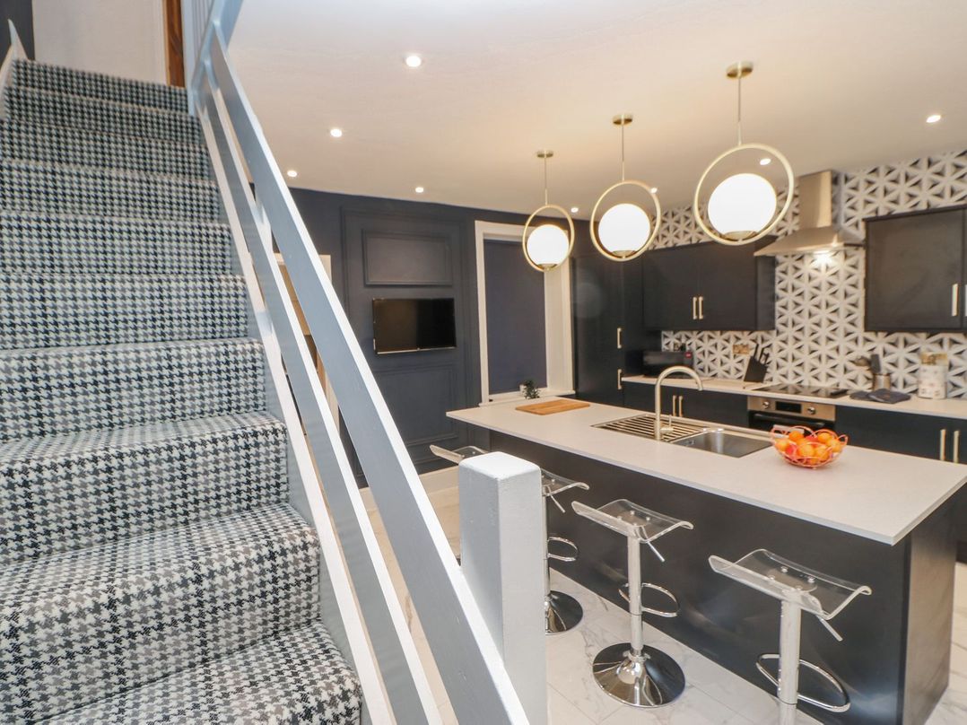 A kitchen with a kitchen island and stools at 16 Seafield Terrace South Shields