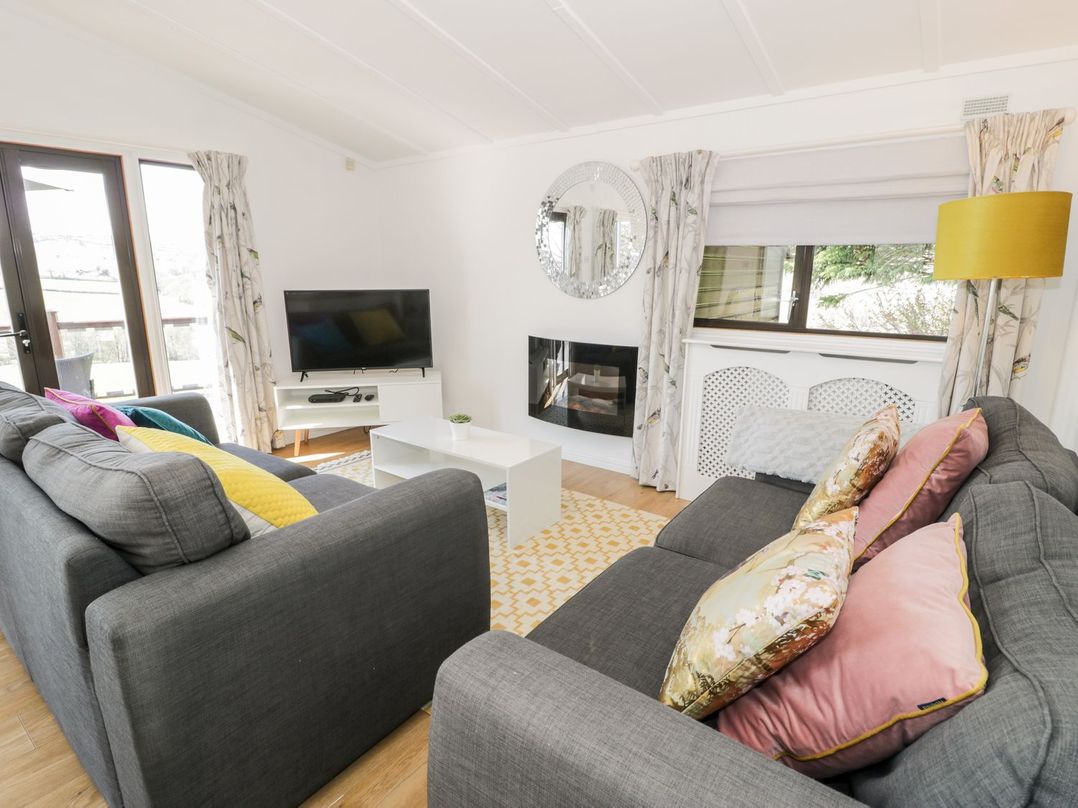 A living room with a television and a coffee table at Summertime Lodge in Rhyd-y-Foel near Abergele