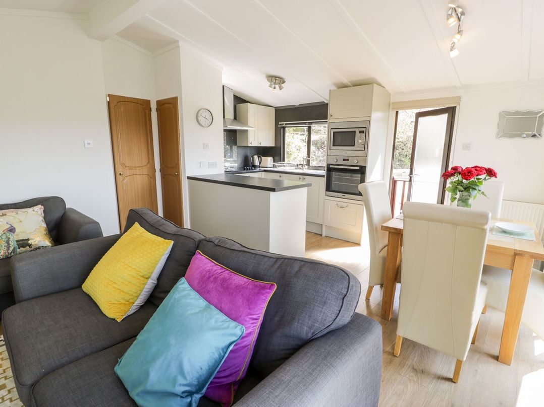 A kitchen with a sofa and table at Summertime Lodge in Rhyd-y-Foel near Abergele