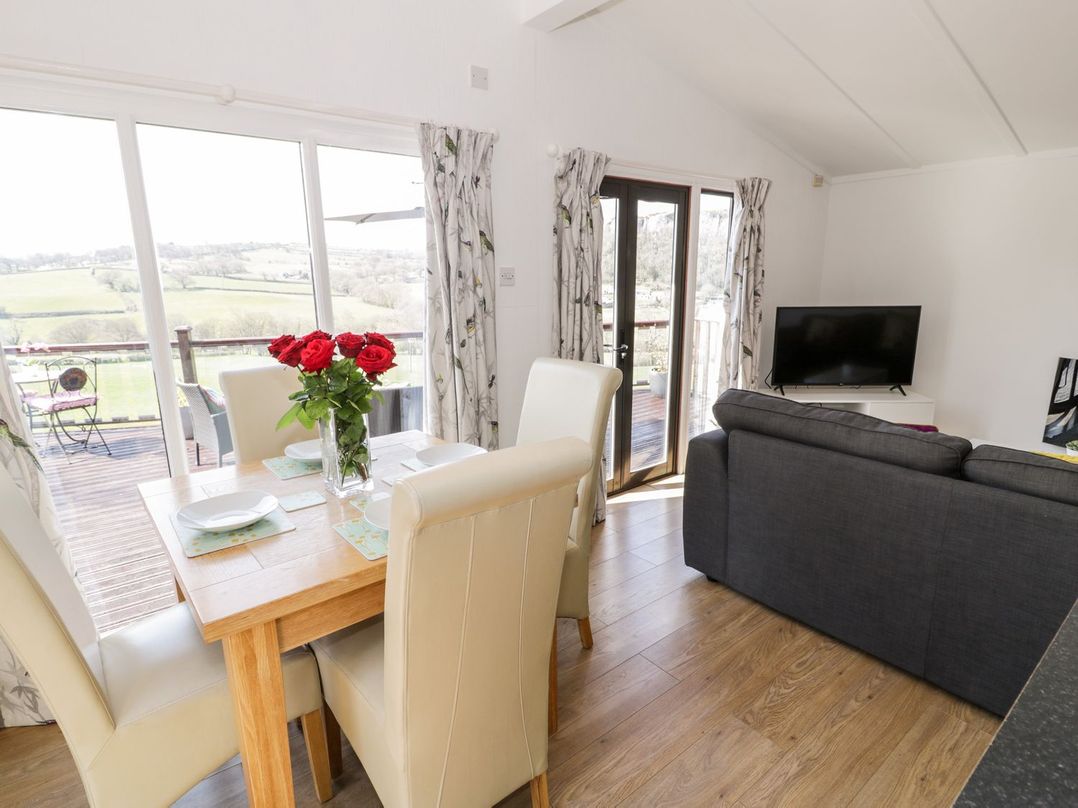 A dining room with a table and chairs at Summertime Lodge Rhyd-y-Foel near Abergele