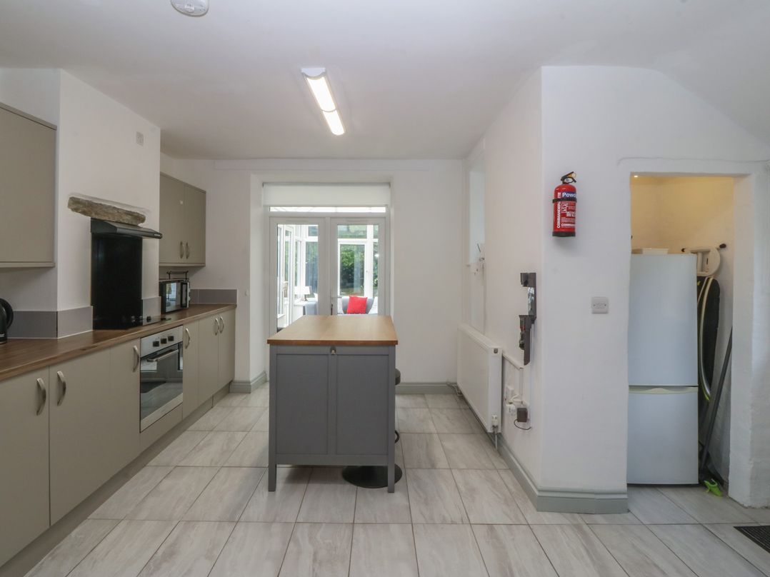 A kitchen with appliances and an island at Seaview Hafod Y Graig Morfa Bychan
